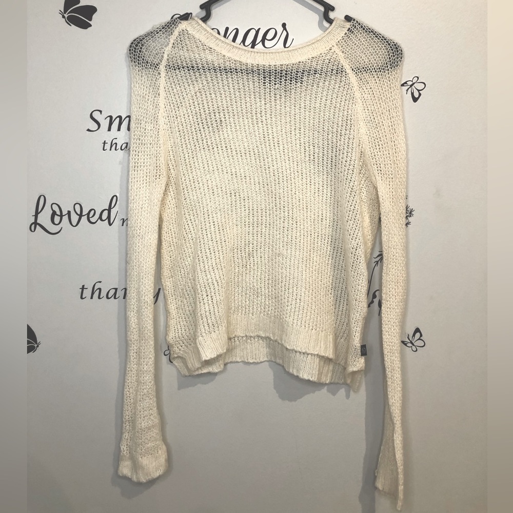 tight knit a sweater. It is stretchy It will have a semi tight/loose fit.